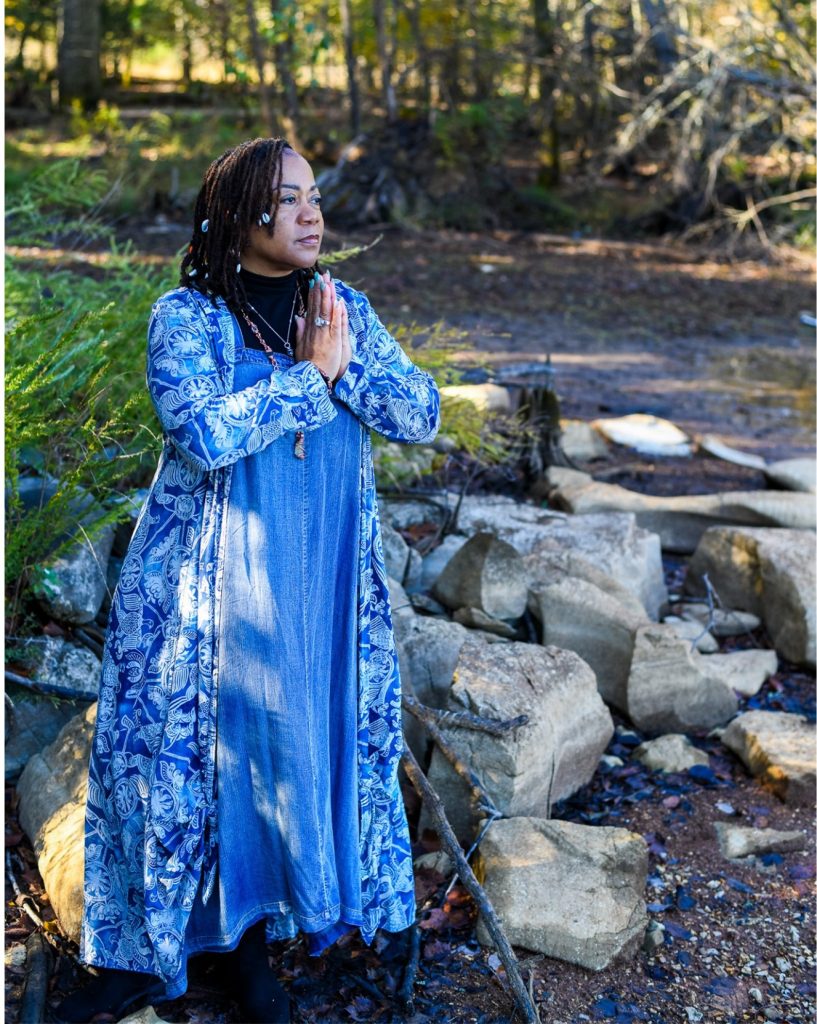 Rosilyn 'Ry' Hart, Reiki Master, in prayer pose outdoors